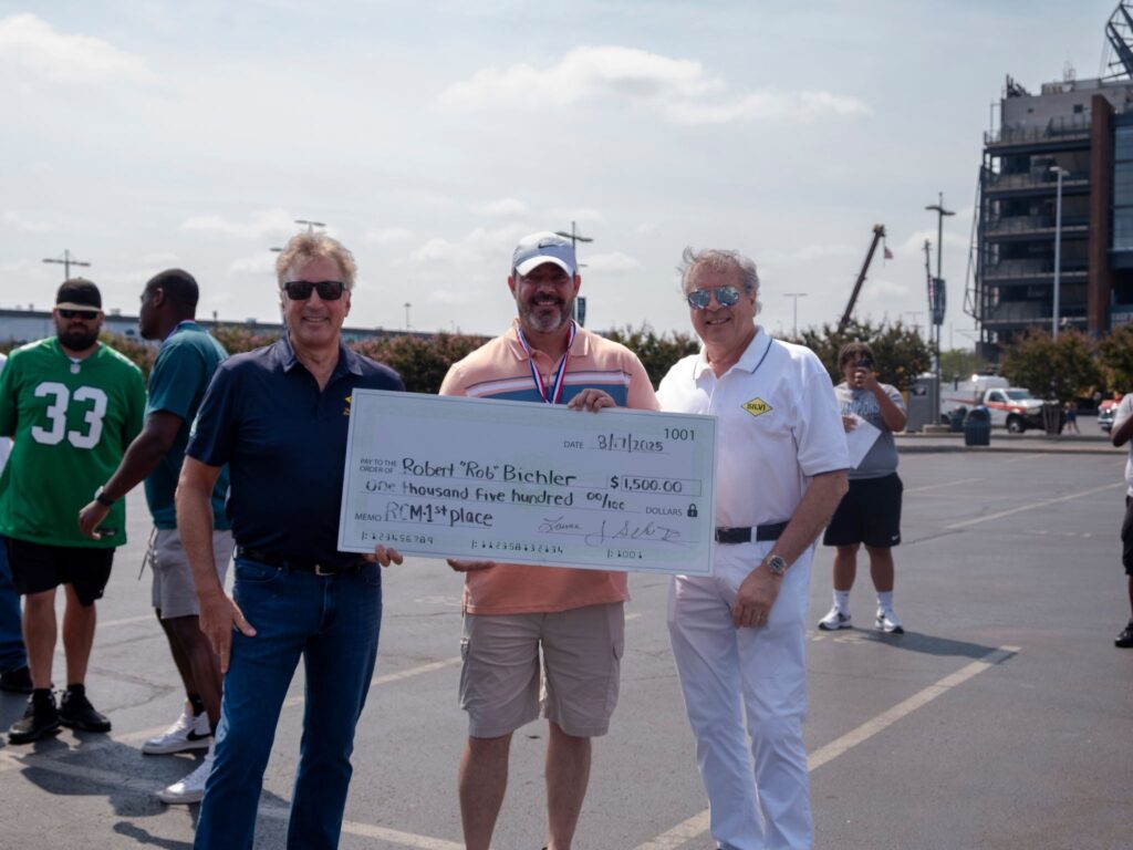 Robert Bichler, winner of the tractor portion of the 2025 Silvi Materials Driver Rodeo posing with owners John and Laurence Silvi. 