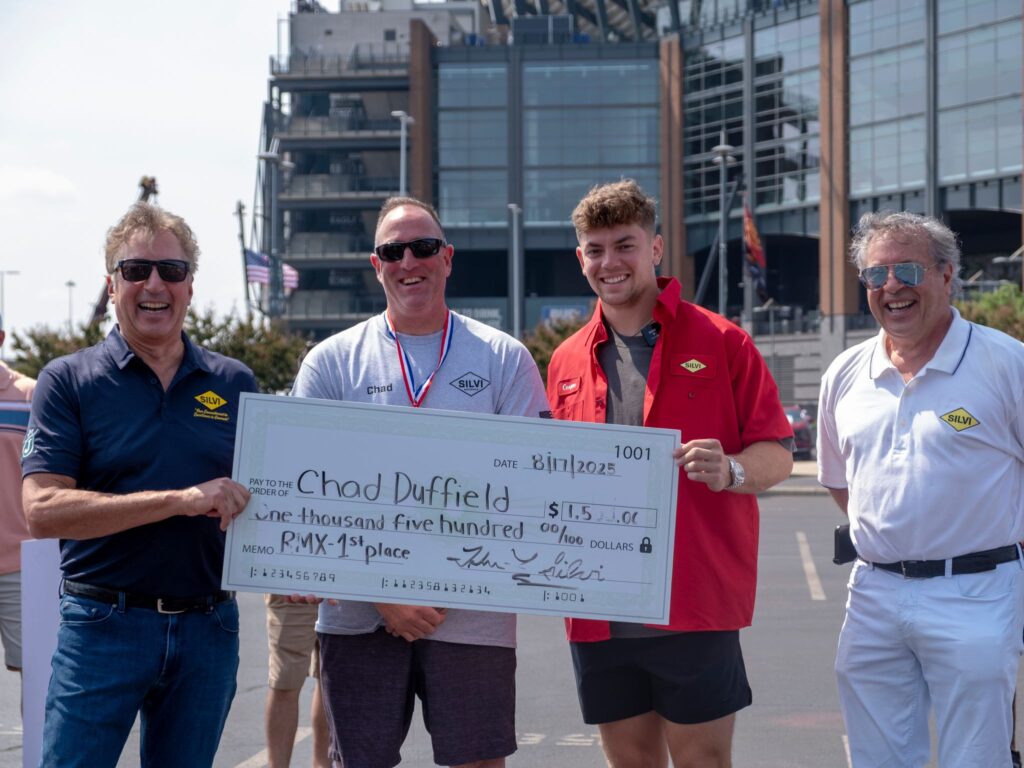 Chad Duffield, winner of the 2025 Silvi Materials Driver Rodeo, poses with owners John and Laurence Silvi and the Philadelphia Eagles' Cooper DeJean. 