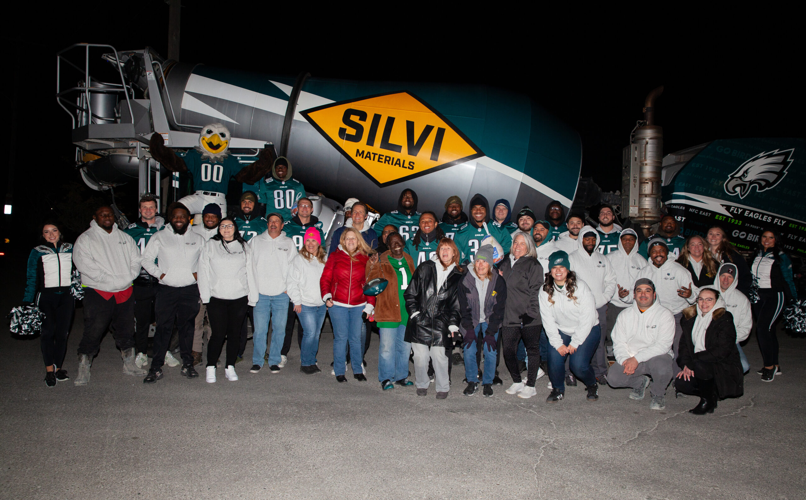A photo of Silvi Materials staff and Philadelphia Eagles players in front of an Eagles-branded concrete mixer truck.
