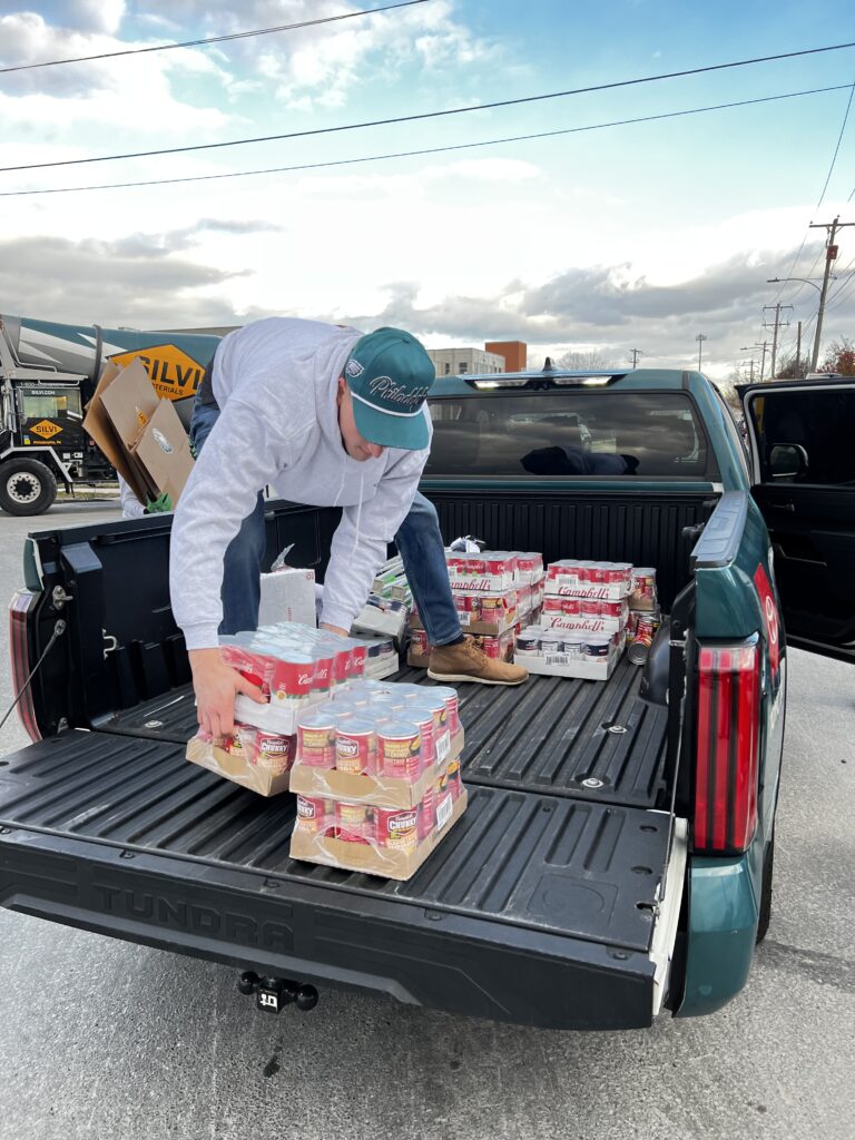 A Silvi Materials employee unloads canned food items at the company's 2025 holiday food drive. 
