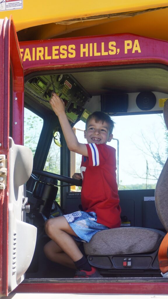 A photo of a child exploring the cab of a concrete mixer truck at the Silvi Foundation Touch-a-Truck. 