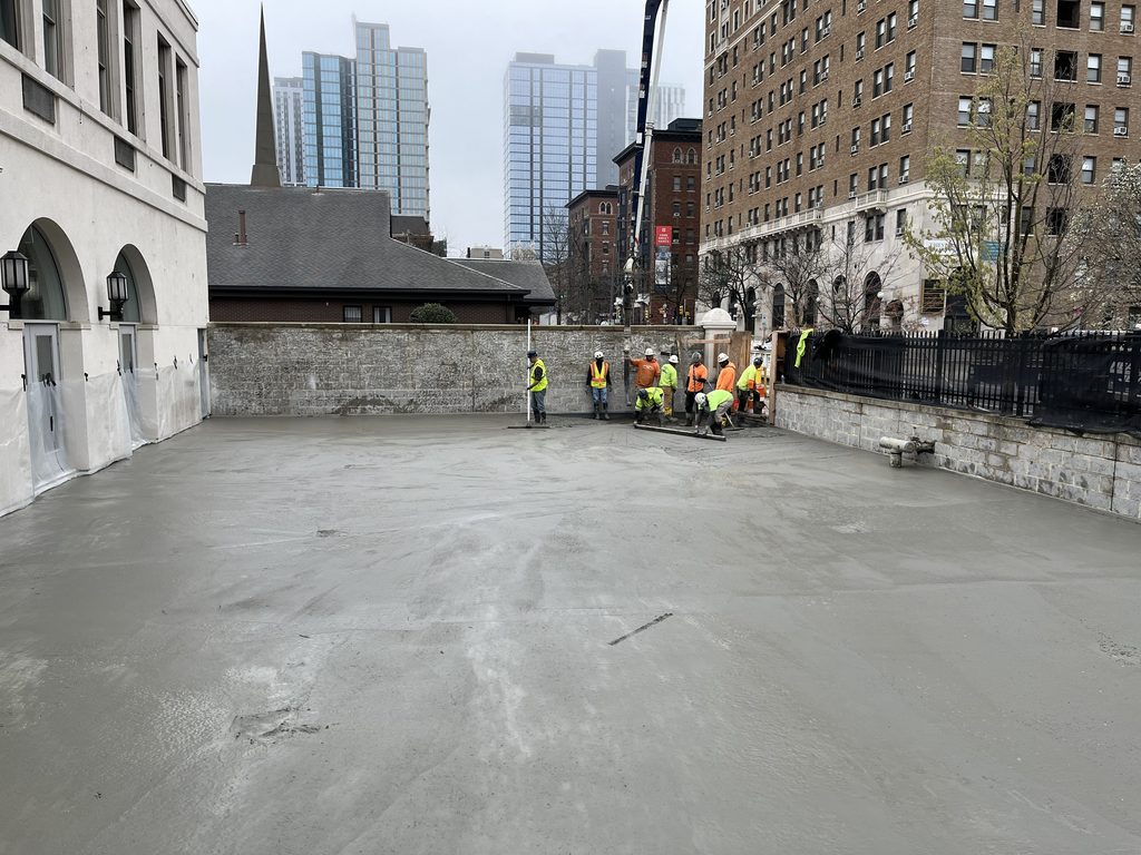 Workers finish freshly poured concrete for the new playground at Ronald McDonald House Philadelphia’s Chestnut Street House.