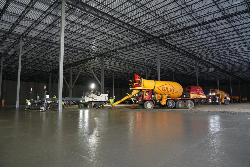 Silvi Materials concrete mixer trucks supplying ready-mix concrete during a large industrial warehouse floor pour.
